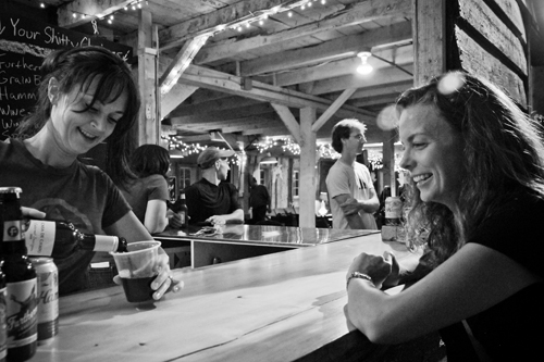 A bartender serves a customer at Sh*tty Barn. Photo by Connie Ward